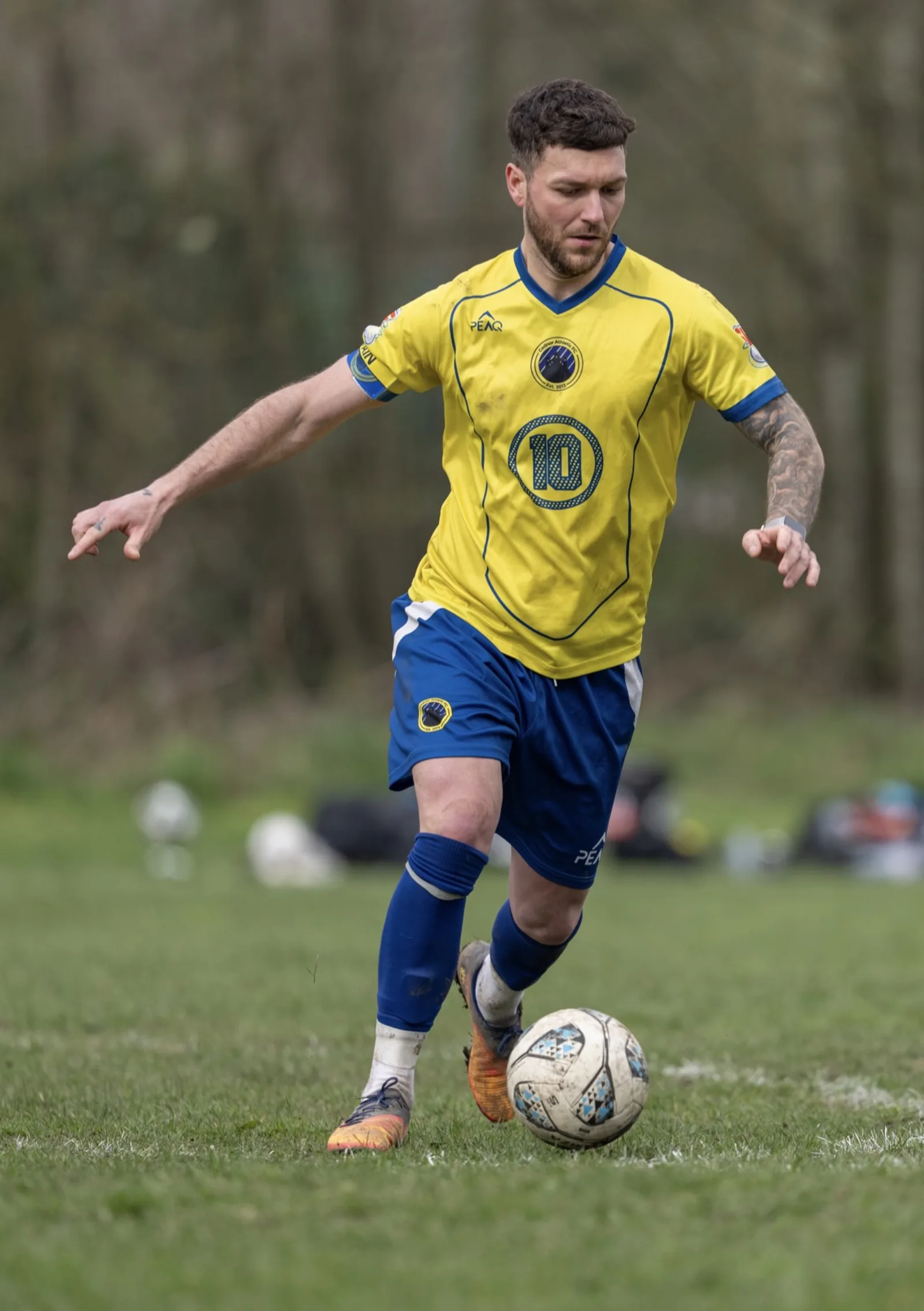 Peaq custom football kit — silicone crest detail under floodlights.
